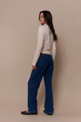 Pantalón de jean azul con parches en denim negro y azul oscuro.