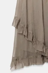 Falda corta de tiro medio con cintura elástica, confeccionada en tejido de viscosa. Presenta un diseño asimétrico con volantes en el bajo.