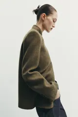 Blazer estructurado de corte recto confeccionado en tejido con lana, con estampado de cuadros en tonos tierra. Presenta cuello subido, cierre frontal con un botón, bolsillos con solapa en la parte inferior y un bolsillo de vivo en el pecho.