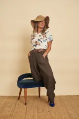 Pantalón de lino marrón oscuro, de corte ancho y relajado, con cintura elástica con cordón ajustable, bolsillos laterales amplios y botamanga recta.