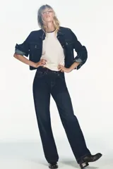 Jeans de tiro alto y pierna ancha con diseño de cinco bolsillos. Presenta una aplicación en la cintura de piel a contraste y cierre frontal con cremallera y botón metálico.