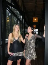 Vestido corto de encaje marrón, con escote en V, corte debajo del busto, mangas largas estilo trompeta y espalda transparente con volado en el ruedo.