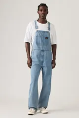 Jardinera de jean en corte holgado, con tirantes ajustables, múltiples bolsillos funcionales y cierre de botones laterales.