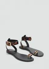 Sandalias planas de cuero con pelo de potro y estampado de leopardo. Poseen tira al tobillo con hebilla metálica y detalle de anillo metálico en la presilla para el dedo.