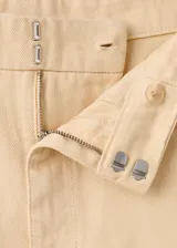 Jeans tiro medio color beige, de corte recto y holgado, con diseño clásico de cinco bolsillos y trabillas para cinturón.