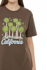 Remera de algodón negro con cuello redondo y diseño holgado, con estampado frontal de líneas horizontales blancas y un corazón rojo superpuesto.