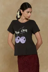 Remera negra de algodón con estampado de cerezas lilas y texto en francés.