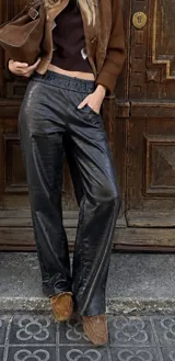 Pantalon oxford de cuerina sintetica en color negro, con textura y patron de imitacion cocodrilo y cintura elastizada.