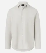 Camisa de sastrería rayada color celeste y blanca, de corte regular, con cuello solapa, cierre frontal de botones y manga larga.