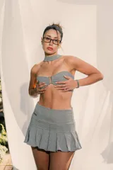 Top strapless de corte ajustado con estampado de cuadros vichy en blanco y negro. Presenta un cierre frontal con gancho metálico y un cuello tipo choker integrado en la misma tela.