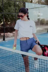 Short biker de lycra azul con franjas laterales rojas y bolsillo para pelotas de tenis.