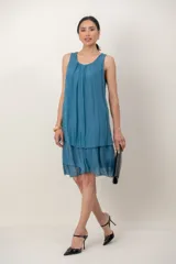 Vestido midi de seda negro con diseño de capas y volados en el bajo, sin mangas y escote redondo fruncido.