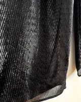 Pantalones negros de pierna ancha con diseño geométrico en lúrex plateado. Tiro medio con detalle de tableados en el frente.