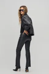 Pantalón negro de cuero legítimo, corte recto y ajustado, con costuras verticales decorativas y cierre metálico lateral.