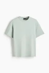 Remera H&M de manga corta color verde menta, de corte holgado con hombros caídos, cuello redondo ribeteado y bajo recto, confeccionada en punto pesado con fibra COOLMAX.