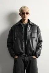 Cazadora acolchada relaxed fit de efecto piel en color negro, con cuello camisero, cierre frontal de cremallera metálica, bolsillos frontales de vivo y puños elásticos.
