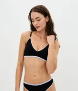 Soutien tipo top de poliamida seamless color negro con detalles contrastantes blancos, copa desmontable, tirantes ajustables y acabado texturizado.