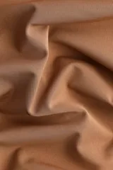 Top entallado de punto elástico color marrón, con hombros descubiertos, escote asimétrico vuelto y costuras fruncidas que generan un efecto drapeado.