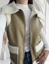 Chaleco color beige con interior de corderito blanco, cierre frontal con cremallera y bolsillos laterales.