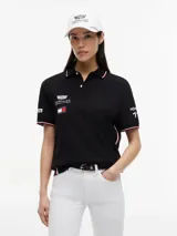 Chomba negra de algodón elástico con cuello polo, cartera de dos botones y mangas cortas. Presenta detalles de ribetes con diseño Global Stripe en el cuello y los puños, además de los logotipos de Tommy Hilfiger, TH x Cadillac Formula 1 Team, Pirelli y el número 11 en las mangas y el pecho.