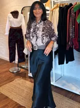 Falda midi de satén en color negro, con corte al bies y caída fluida que se ajusta suavemente a la silueta.