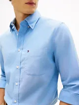 Camisa de corte regular confeccionada en algodón Oxford elástico y ligero, color celeste. Cuenta con cuello abotonado, mangas largas con puños redondeados, bolsillo de parche en el pecho con el logo bordado y bajo redondeado.