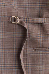Blazer de corte recto con estampado a cuadros, escote en pico sin solapas y frente superpuesto. Presenta hombreras, bolsillos delanteros ribeteados, aberturas en los puños y un cinturón fino extraíble con anillas en D para ajustar en la cintura.