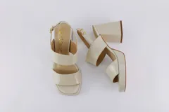 Sandalias de plataforma color crema, con tiras anchas de charol y hebilla ajustable en el tobillo.
