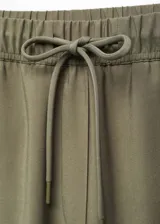 Pantalon de corte fluido y estilo jogger, color verde militar, con cintura elástica y lazo ajustable. Cuenta con dos bolsillos laterales y diseño de largo tobillero.