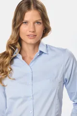Camisa lisa de color blanco, de corte clásico y entallado, con mangas largas y cierre frontal con botones.