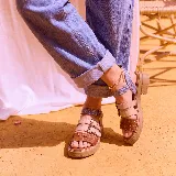 Sandalias de plataforma baja con múltiples tiras frontales y tobillera ajustable con hebilla, combinando tonos marrón, beige y texturas estampadas.