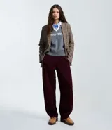 Pantalón de corte barrel en color bordó, confeccionado en tejido de algodón con felpa. Presenta cintura elástica, bolsillos laterales y pinzas en la zona de la rodilla que aportan volumen a la prenda.
