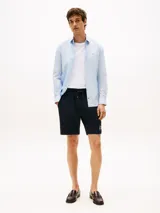 Camisa celeste de popelina con tecnología flex, corte slim, cuello abotonado, cierre con botones, manga larga y logo de Tommy Hilfiger bordado en el pecho.