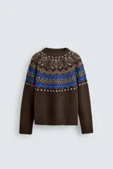 Jersey de punto con diseño jacquard geométrico en la parte superior, cuello redondo y manga larga. Presenta un corte relajado con acabados en rib en puños y ruedo.