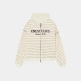Campera con capucha y cierre frontal completo, de corte oversize. Presenta un diseño a rayas horizontales en tonos arena y blanco, con el logo de la marca estampado en el pecho.