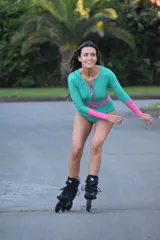 Malla enteriza de manga larga en color verde con detalles en fucsia en las mangas, cintura y cierre frontal. Posee un diseño deportivo con cuello redondo y cierre central.