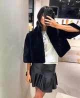 Minifalda de cuero color marrón oscuro, con fajón en la cintura y volados en el ruedo.