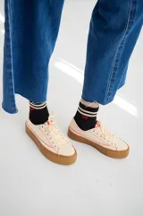 Championes de lona color negro con plataforma de goma color suela. Presentan cordones negros y costuras decorativas en contraste.