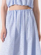 Pollera midi celeste con pequeños strass plateados, de corte amplio y cintura elastizada.