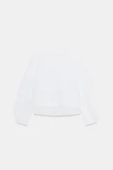 Camiseta oversize de cuello redondo y manga larga con puños abotonados. Confeccionada en algodón, presenta un diseño con combinación de tejidos a tono y bajo asimétrico.