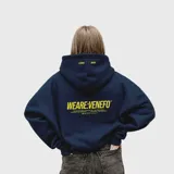 Hoodie de algodón color azul marino con capucha, diseño oversize y estampado gráfico en amarillo en la espalda y en la parte superior de la capucha.