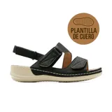 Sandalia plana Korium Confort Beryl de color negro, con diseño ergonómico y múltiples tiras con cierre de velcro para un ajuste personalizado. Cuenta con suela de goma en tono beige y pespuntes blancos decorativos.