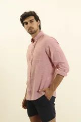 Camisa de manga larga confeccionada en una mezcla de algodón y lino, con cuello abotonado, cierre frontal de botones y un bolsillo en el pecho.