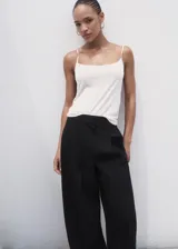 Pantalón wide leg de tiro medio color negro, con diseño largo, bolsillos laterales, bolsillos de ribete posteriores y detalle de pinzas. Cuenta con cierre oculto de botón, gancho y cremallera, e incluye forro interior.