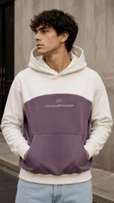 Canguro con capucha y bolsillo tipo canguro, diseño en bloque de color blanco en la parte superior y mangas, y morado oscuro en la parte central e inferior. Presenta el logo de la marca bordado en el pecho.