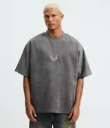 Remera oversized gris con efecto acid wash y tacto gamuza, de mangas cortas y cuello redondo. Presenta un pequeño bordado con estampa lettering en el centro del pecho.