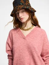 Sweater de punto color rosado, con cuello polo y escote en V. Tiene manga larga con puños ajustados y ruedo en punto ajustado.