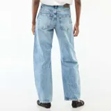 Pantalón jean de corte globo con tiro alto, confeccionado en denim de lavado claro con costuras frontales verticales en el bajo.