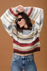 Sweater de punto con diseño de rayas horizontales en tonos marrón chocolate, rojo, beige, gris y blanco. Presenta cuello redondo y mangas largas con puños ajustados.