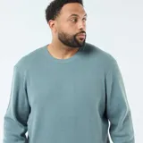 Sweater de punto gofrado, color azul verdoso, de manga larga y cuello redondo.
